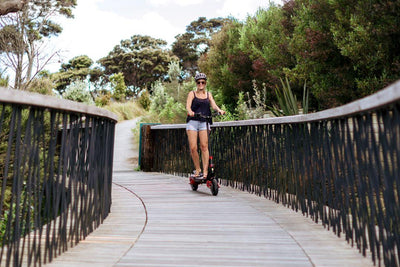 Woman happily folding her electric scooter