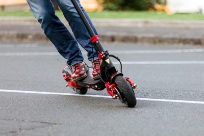 A person standing next to their e-scooter learning how to ride an electric scooter safely