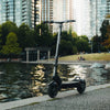 Electric scooter by a body of water with city skyline in the background
