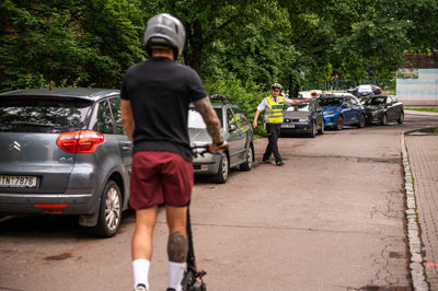 Person on an electric scooter with a traffic officer in a parking lot.