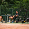 Two people sitting on a tennis court with Teverun fighter Mini electric scooters.