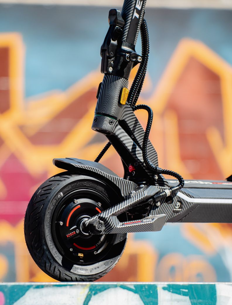 Close-up of a Teverun fighter Mini  electric scooter with a colorful graffiti background