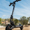 Teverun fighter Mini  Electric scooter on a paved area with trees and clear sky in the background