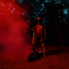 Person on a Teverun Fughter Supreme Ultra electric scooter  with red smoke in a dark forest setting