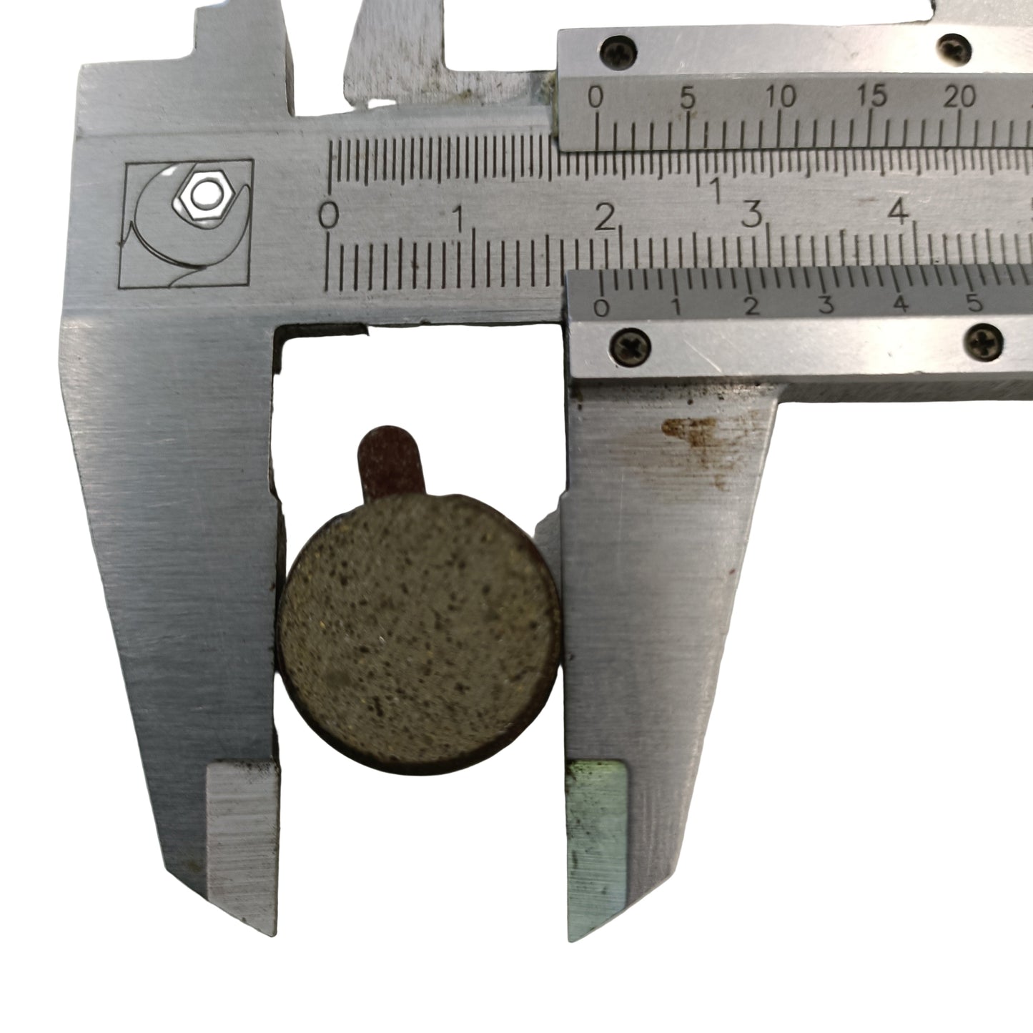 Vsett 9 scooter brake pad being measured with a vernier caliper on a white background pad