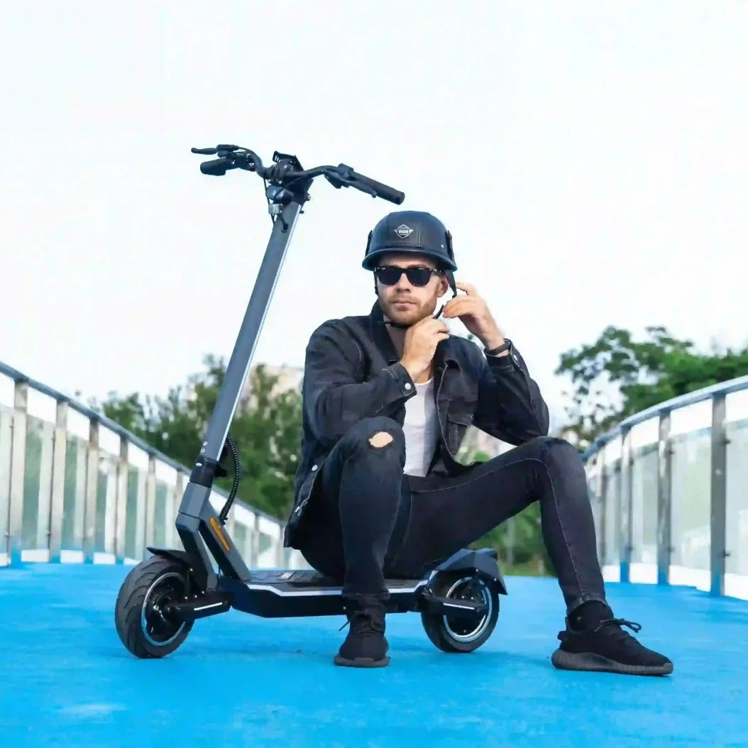 Man sits on the deck of his Punk Rider Pro electric scooter